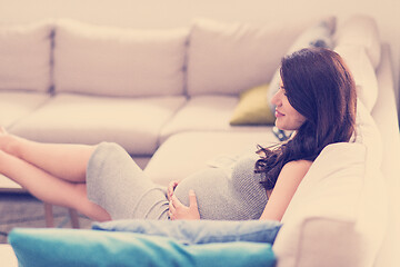 Image showing pregnant woman sitting on sofa at home