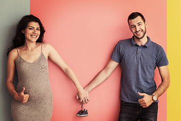 Image showing young happy couple holding newborn baby shoes