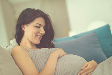 Image showing pregnant woman sitting on sofa at home