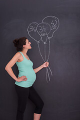 Image showing Portrait of pregnant woman in front of black chalkboard