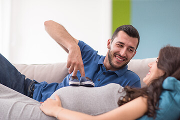 Image showing young pregnant couple relaxing on sofa