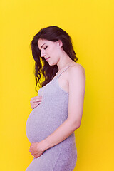 Image showing Portrait of pregnant woman over yellow background