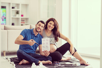 Image showing pregnant couple checking a list of things for their unborn baby