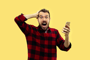 Image showing Half-length close up portrait of young man on yellow background.