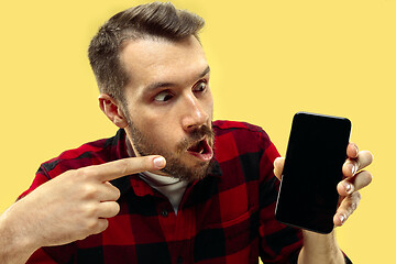 Image showing Half-length close up portrait of young man on yellow background.