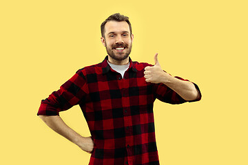 Image showing Half-length close up portrait of young man on yellow background.