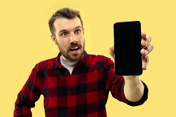 Image showing Half-length close up portrait of young man on yellow background.