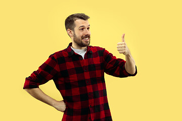 Image showing Half-length close up portrait of young man on yellow background.