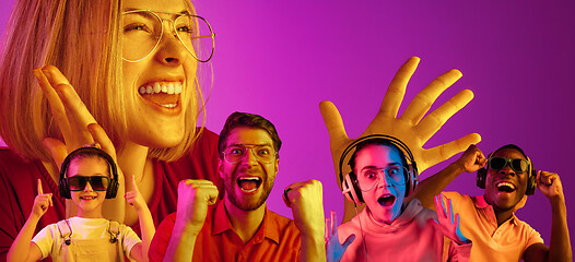 Image showing Beautiful young people in neon light isolated on pink studio background