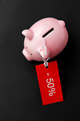 Image showing piggy bank with red sale tag on black