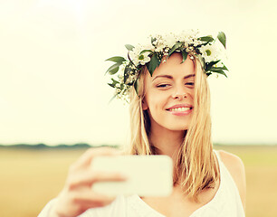 Image showing happy young woman taking selfie by smartphone