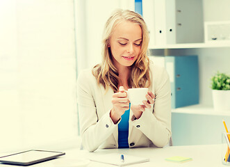 Image showing happy businesswoman drinking coffee at office