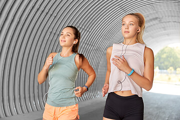 Image showing women or female friends with earphones running