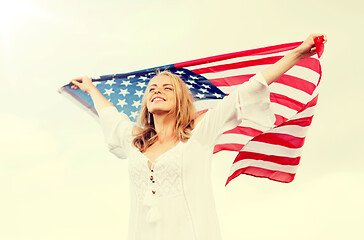 Image showing happy young woman with american flag outdoors