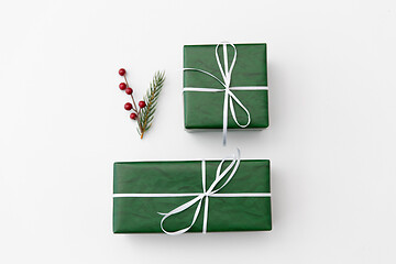 Image showing green gift boxes and fir tree branch with berries