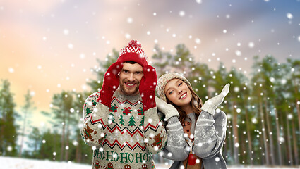 Image showing happy couple in ugly christmas sweaters in winter