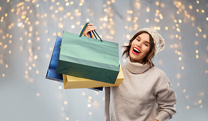 Image showing young woman in hat with shopping bags on christmas