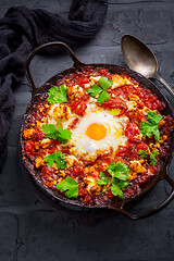 Image showing Shakshuka -  dish of eggs poached in a tomato sauce with Feta cheese and coriander