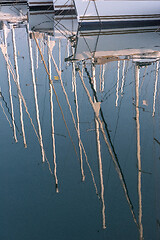 Image showing Reflection of masts in the water.