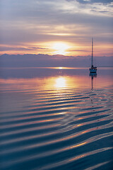 Image showing Moored sailboat in the bay and sunrise