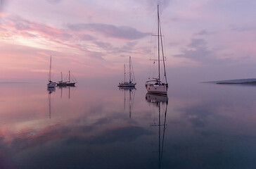 Image showing Moored sailboats in the bay before sunrise