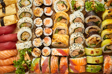 Image showing Top view background with set of colorful different kinds of sushi rolls placed on wooden board