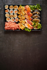 Image showing Sushi take-away plastic tray with diffent kinds of rolls and copy space. Take-away food concept.