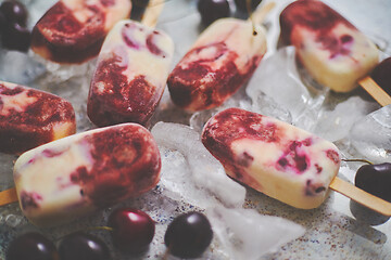 Image showing Delicious, homemade popsicles made from cherries and cream.