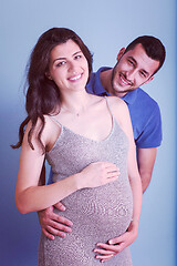 Image showing pregnant couple  isolated over blue background