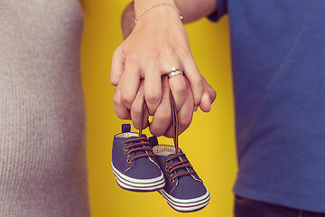 Image showing couple holding newborn baby shoes