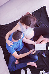 Image showing top view of couple checking a list of things for their unborn ba