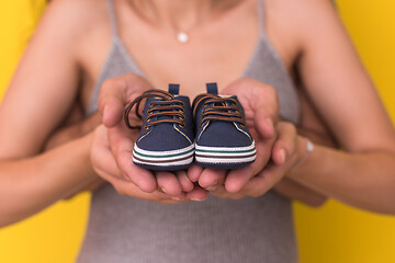 Image showing couple holding newborn baby shoes