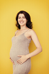 Image showing Portrait of pregnant woman over yellow background