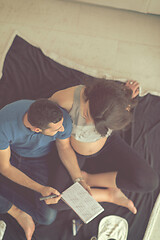 Image showing top view of couple checking a list of things for their unborn ba