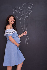 Image showing Portrait of pregnant woman in front of black chalkboard