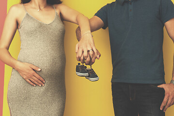 Image showing couple holding newborn baby shoes