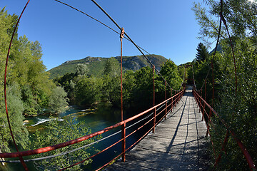 Image showing wooden bridge over wild river