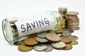 Image showing Saving lable in a glass jar with coins spilling out