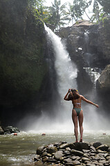 Image showing Young beautiful tourist visiting the Tegenungan waterfall in Bal