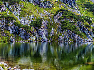 Image showing Mountain slope with small lake at botom