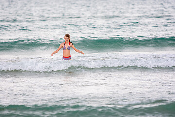 Image showing Happy girl swims alone in the sea