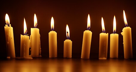 Image showing Candles glowing against dark background