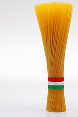 Image showing Bundle of spaghetti and Italian flag on the white table