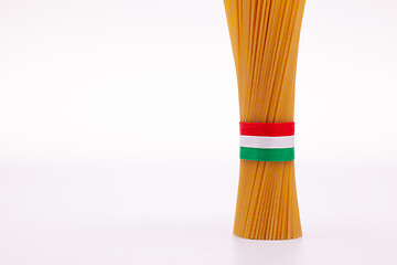 Image showing Bundle of spaghetti and Italian flag on the white table