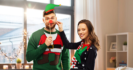 Image showing couple with christmas party props in ugly sweaters