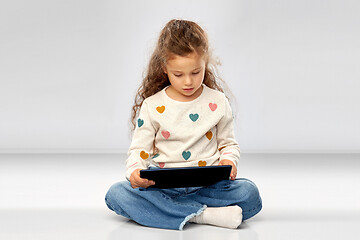 Image showing smiling girl with tablet computer sitting on floor