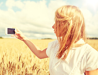 Image showing close up of girl with smartphone on cereal field