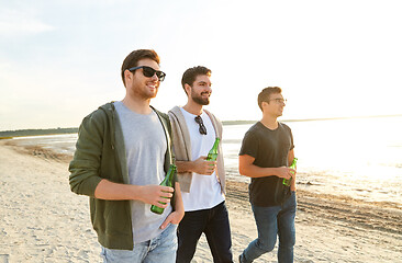 Image showing young men with non alcoholic beer walking on beach