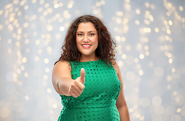 Image showing happy woman showing thumbs up over lights