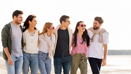 Image showing happy friends walking along summer beach